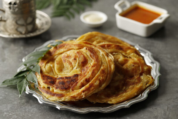 Close Up Roti Canai or Paratha with Chicken Curry